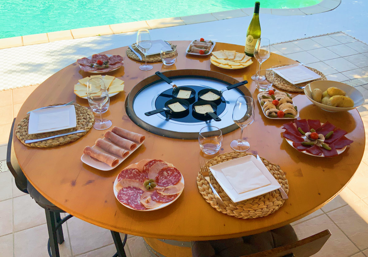 Table de raclette dressée sur un Tonneau Gourmand, au bord de la piscine