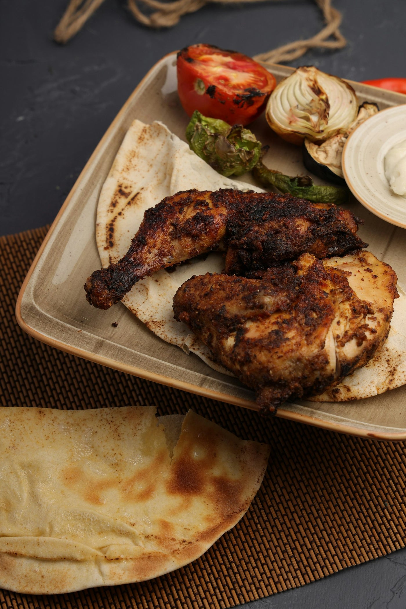Poulet grillé, légumes et pain pita servis dans une assiette