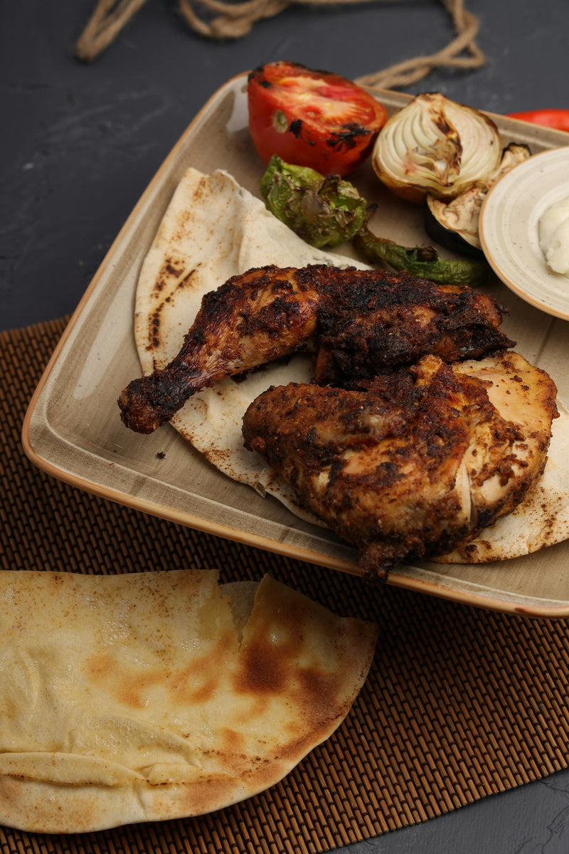 Poulet grillé, légumes et pain pita servis dans une assiette
